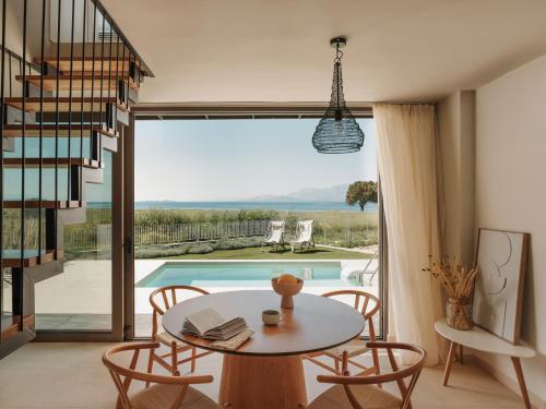 a dining room with a table and chairs and a pool at springs suites no4 in Kato Alepochori
