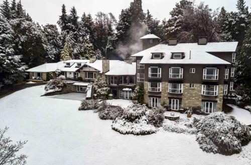 ein großes Haus mit Schnee auf dem Boden in der Unterkunft La Cascada Casa Patagónica by DON in San Carlos de Bariloche