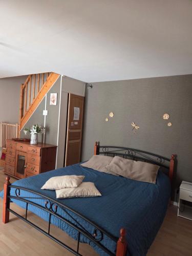 a bedroom with a bed with a blue comforter at Le relais de la cure in Saint-Juire-Champgillon