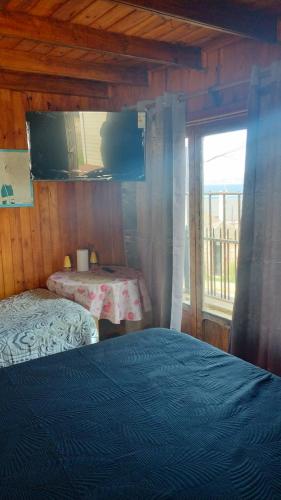a bedroom with two beds and a window with a table at Paldoa in Pichilemu