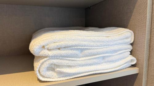 a stack of white towels sitting on a shelf at Apartamento Premium com 2 quartos in Palmas