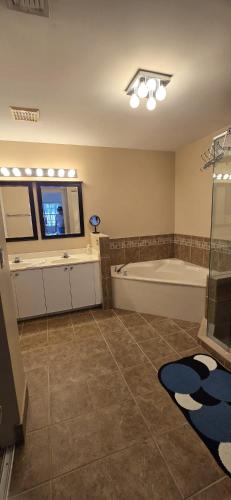 a large bathroom with a tub and a tv in it at Across from Sawgrass Mall- Next to Amerant Bank Arena in Sunrise