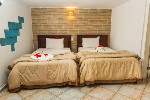 two beds with christmas decorations on them in a room at Tropic Garden Hotel in Banjul