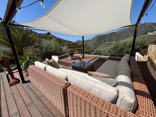 a patio with a couch and an umbrella at Finca RustiQ in Torrox
