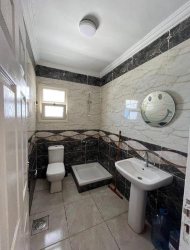 a bathroom with a toilet and a sink at شالية ديمورا للعائلات in Dawwār Muḩammad Abū Shunaynah