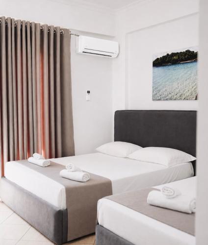 a room with two beds and a window at Corner Hotel in Ksamil