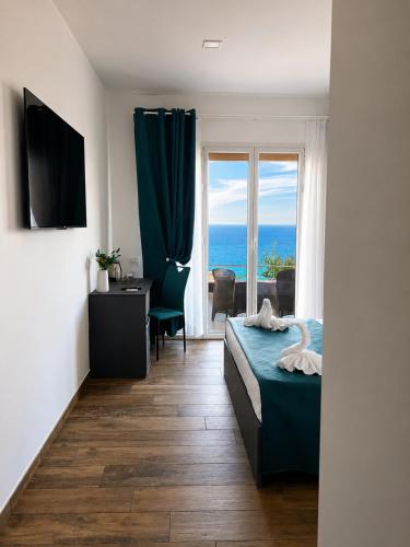 a bedroom with a bed and a view of the ocean at Infinity Blue in Cefalù