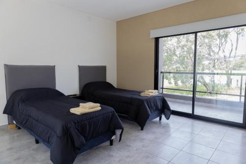 a room with two beds and a large window at Almería Suites in Salta