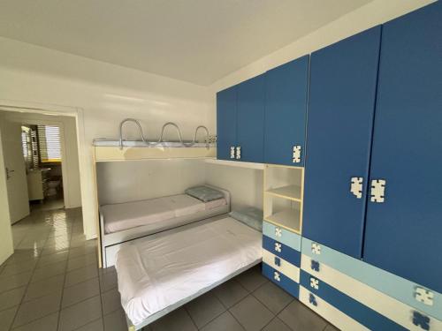a room with two bunk beds and blue cabinets at Appartamento Fronte Mare con ombrellone e sedie sdraio incluse nel costo in Pescara