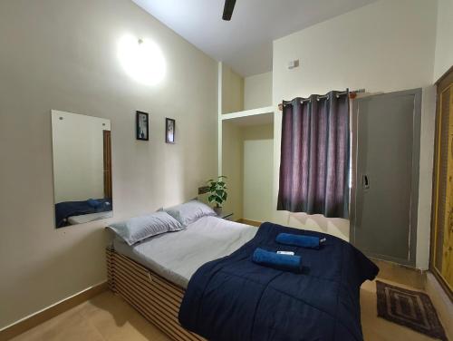 a bedroom with a bed with a blue blanket at Galaxy Homestay 4Bhk AC in Mysore
