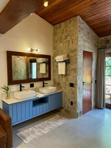 a bathroom with two sinks and a mirror at Gaia Hotelaria in Teresópolis