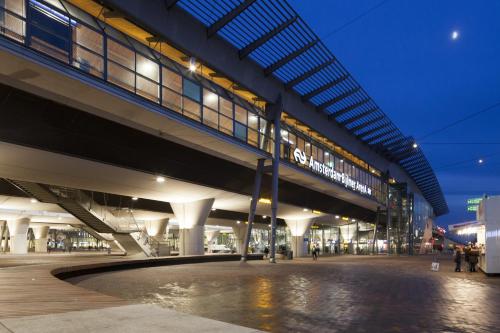 a night view of a building with people walking under it at easyHotel Amsterdam Arena Boulevard in Amsterdam