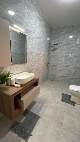a bathroom with a sink and a toilet and a shower at Le Refuge, Residence Ibrahima in Rufisque