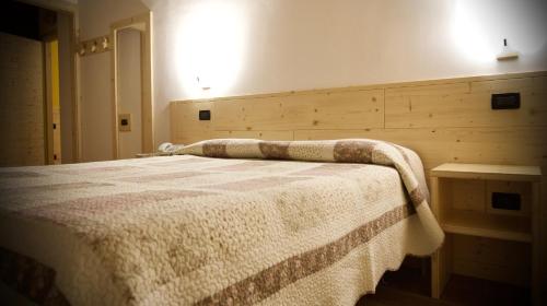 a bedroom with a bed with a blanket on it at Locanda Fungo Reale in Valloriate