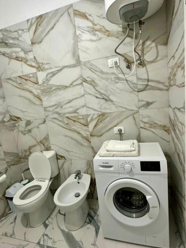 a bathroom with a toilet and a washing machine in it at Sea flavor 2 in Shëngjin