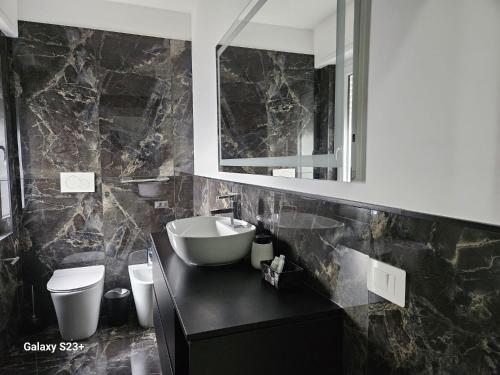 a bathroom with a sink and a toilet and a mirror at Residence Niko 5 Pomezia in Pratica di Mare