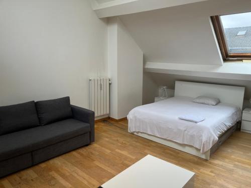 a bedroom with a bed and a couch at Cosy uccle chic flat in Brussels
