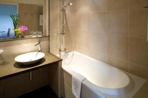 a bathroom with a sink and a bath tub at Les Jardins de Bakea in Biriatou
