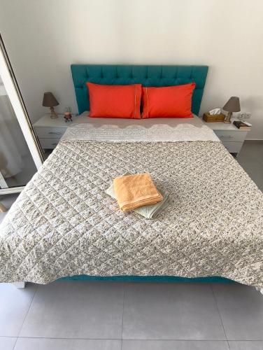 a bedroom with a bed with a blue headboard and red pillows at Mok's House in Kavála