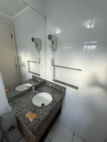 a bathroom with two sinks and a mirror at Lacqua diRoma in Caldas Novas