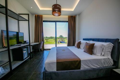 a bedroom with a bed and a desk and a television at Olive Farmhouse in Hamallë