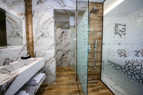 a bathroom with a shower with a glass door at Olive Farmhouse in Hamallë