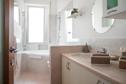 a white bathroom with a sink and a bath tub at Milan Top-Floor Flat City View 2 Balconies Workspace M5 in Milan