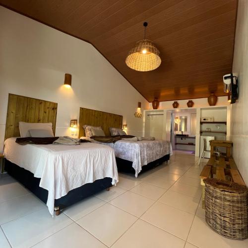 a bedroom with two beds in a room at Vila Capininga Ecopousada in Santo Amaro