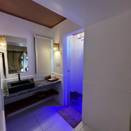 a bathroom with a sink and a shower at Vila Capininga Ecopousada in Santo Amaro