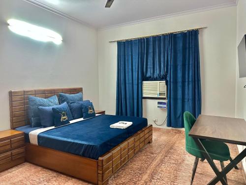 a bedroom with a bed and a desk and a window at Blooming Inn in Gurgaon