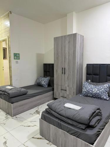 two beds in a room with a mirror at Makank Jo in Aqaba