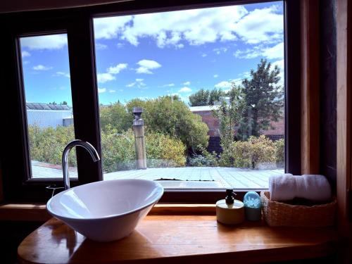 a bathroom with a sink and a large window at Yagan house in Puerto Natales