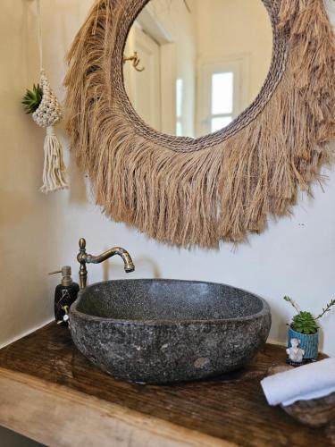 a bathroom with a stone sink and a mirror at Fino Amore Private Jacuzzi Suite in Mykonos Town in Mikonos