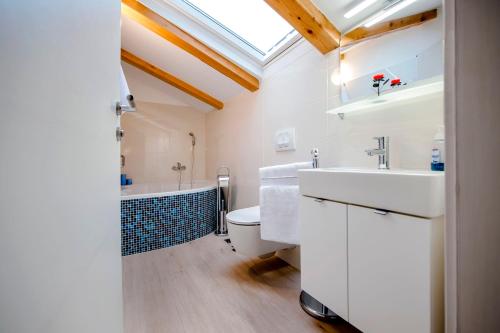 a bathroom with a sink and a toilet and a tub at Villa Masi in Kanfanar