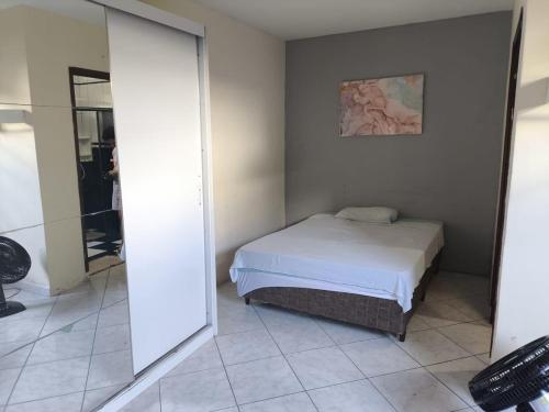 a bedroom with a bed in a room with a mirror at Quarto Bem Localizado em Lugar Tranquilo in Barueri