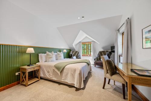 a bedroom with a bed and a desk in a room at Wanaka Homestead Lodge & Cottages in Wanaka