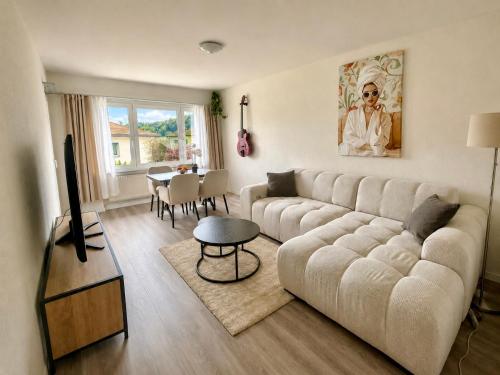 a living room with a couch and a table at Topview 2BR Balcony & Mountain View Interlaken in Unterseen