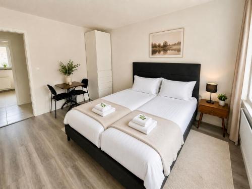 a bedroom with a large white bed and a table at Topview 2BR Balcony & Mountain View Interlaken in Unterseen