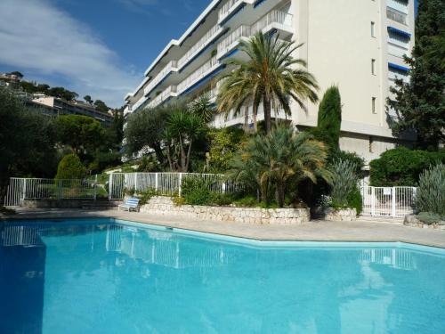 une grande piscine bleue devant un immeuble dans l'établissement La Reale, à Villefranche-sur-Mer