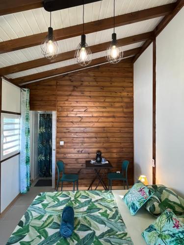 a bedroom with a bed and a wooden wall at Les gîtes Lanmou 1 in La Désirade