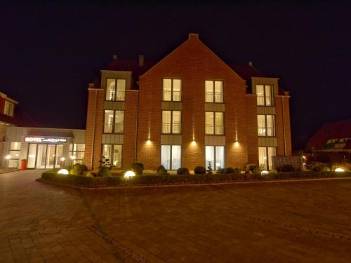 a large brick building with lights in front of it at Hotel Friesische Wehde in Bockhorn