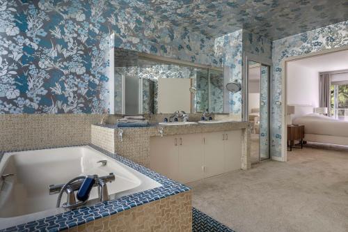 a bathroom with a tub and a sink at Villa 96 Golf de la Baule avec piscine et spa in Saint-André-des-Eaux