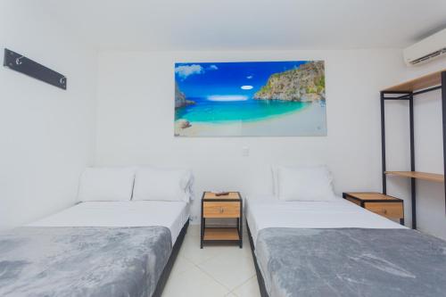 ein Zimmer mit zwei Betten und einem Gemälde an der Wand in der Unterkunft Hotel San Jeronimo Tropical in San Jerónimo