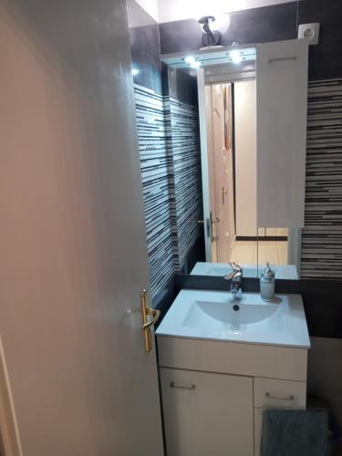 a bathroom with a white sink and a mirror at Adam Apartman in Hajdúszoboszló