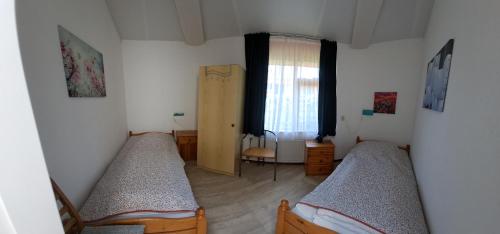 a bedroom with two beds and a window at Seestern 61 in Julianadorp