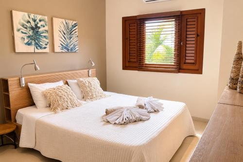 a bedroom with a bed with white sheets and a window at JeVakantie Spanish Water Apartments B7 and C8 with Infinity Pool near Jan Thiel in Willemstad