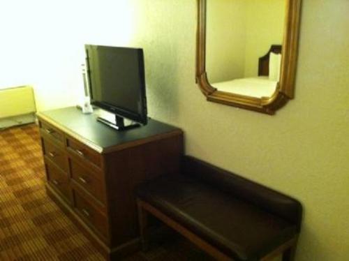 a room with a dresser with a tv and a mirror at Waterford Inn in Waterford