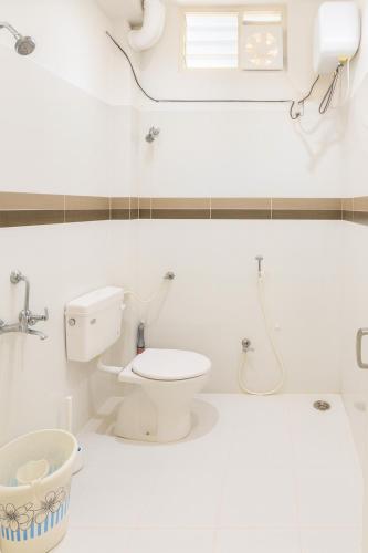 a white bathroom with a toilet and a window at NK Luxe Apartments - Full Furnished 2BHKs, Free Wifi, Smart TV, Central Location in Hyderabad
