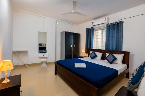 a bedroom with a large bed with a blue blanket at NK Luxe Apartments - Full Furnished 2BHKs, Free Wifi, Smart TV, Central Location in Hyderabad