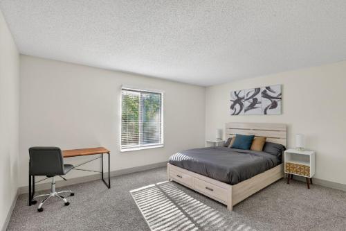 a bedroom with a bed and a desk and a window at Contemporary 2BR apartment with workspace in Lenexa
